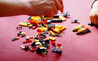 Kind spielt mit Lego Bausteinen