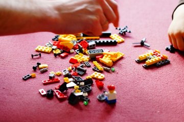 Kind spielt mit Lego Bausteinen